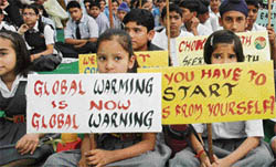 Schoolchildren carry placards against global warming on World Health Day in Patiala