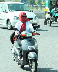 A girl covers her face with a dupatta to beat the heat in Jalandhar on Thursday.