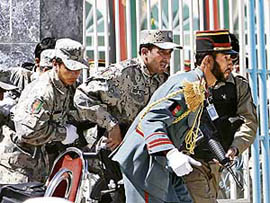 Afghan security personnel escape from an attack at a function near the presidential palace in Kabul on Sunday.