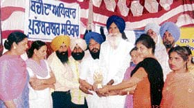 Rupinder Kaur, child development project officer, felicitates community workers for their excellent work against foeticide during a seminar in Ludhiana