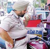 A police officer drinks lemon juice on a hot day on Wednesday in Ludhiana.