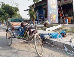an inebriated rickshaw-puller sleeps outside a liquor shop in Phase X, Mohali, on Thursday