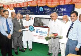 Chief general manager of State Bank of India Ajay Swaroop hands over the keys of a Maruti van to Vijay Chopra, chief patron of Himotkarsh Sahitya Sanskriti and Jan Kalyan Parishad, a society working for the underprivileged in Himachal Pradesh in Chandigarh on Thursday.