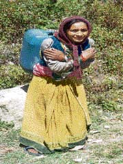 A women carrying a can of water on her back in Garhwal Himalayas