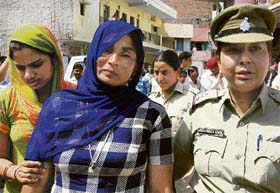 The wife of the priest being escorted by the women police in Chandigarh