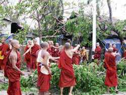 Monks clear fallen trees from a road in Yangon on Monday after "Cyclone Nargis" swept through parts of the country.