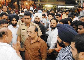 Enforcement officials argue with a shopkeeper in the Sector 22 Shastri Market, Chandigarh