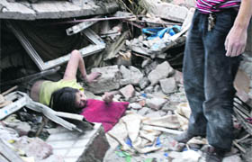 A Chinese woman tries to escape from the debris of a collapsed building after an earthquake measuring 7.8 in Dujjangyan, Sichuan province, on Monday.
