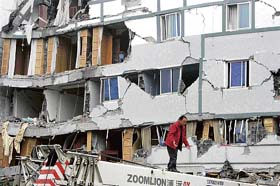 A rescue worker searches for victims in the debris of a building in Dujiangyan