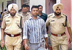 Jasbir Singh being taken away by a police officer in Pathankot
