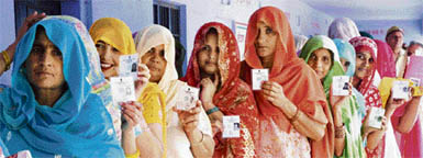 Women, armed with photo-identity cards, line up to vote in Garhi Birbal village of the Indri assembly constituency in Karnal district.