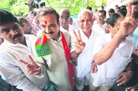 BJP's chief ministerial candidate B.S. Yedyurappa (second from right) accompanied by other leaders greets party supporters as they arrive at the party office in Bangalore
