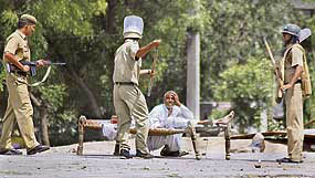 Policemen beat an agitator who was guarding the body of his brother allegedly killed in firing at Pattikalyana village, near Panipat, during Gujjar violence on Thursday.