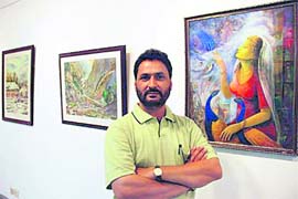 Ashwani Verma poses with his paintings at his exhibition ‘Feeling of Nature’ at Punjab Kala Bhawan, Sector 16, Chandigarh on Sunday.
