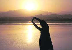 A woman performs yoga at sunrise at the Sukhna Lake in Chandigarh on Saturday.
