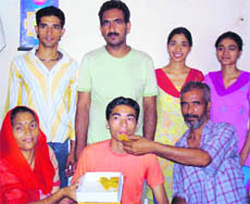 Neeraj Saini with his parents and other family members at his home at Gandla Lahri in Pathankot on Saturday . Photo: N. P. Dhawan