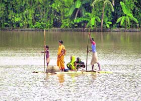 A family moves to a safer place on a raft made from banana tree shoots in the flood affected Bantow village in Lakhimpur district, about 400 km east of Guwahati