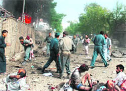 Afghan security force personnel assist survivors at the scene of the suicide bombing outside the Indian embassy in Kabul on Monday.