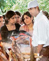 Brig R. D. Mehtas widow Sunita along with her daughter and son holds the national flag and the military cap and belt of her husband at his cremation in New Delhi