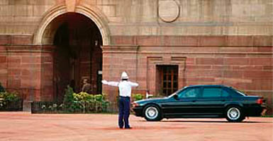 A policeman gestures to a car carrying Prime Minister Manmohan Singh towards a meeting with President Prathiba Patil at Rashtrapati Bhawan in New Delhi on Thursday.