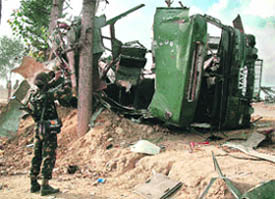 An Army jawan takes pictures of what remains of the bus that was blasted by militants on the Srinagar-Baramulla highway on Saturday. The bus was a part of an Army convoy bound for Srinagar from Baramulla.