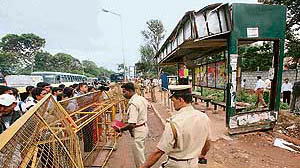 Policemen stand guard at the Madivala bus stand where a woman died in a bomb blast on Friday.