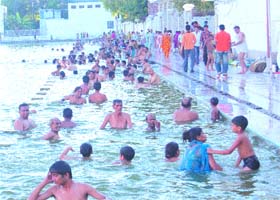 Devotees take a holy dip in the sarovar of the Durgiana Temple in Amritsar during the solar eclipse