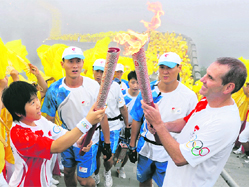 Torchbearers Wang Ning (left) and Colin Giles (right) exchange the flame as they take part in the Olympic torch relay along a section of the Great Wall in Badaling, outside Beijing on Thursday, a day before the start of the 2008 Games. The second day of the torch relay was shrouded in a sea of haze.