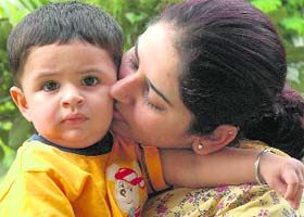 Depinder Kaur kisses her 10-month-old son Aviraj after getting the interim custody in Chandigarh