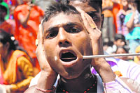 A devotee’s cheeks pierced with an iron rod by a priest during the Sheetla Mata puja at Sukhna Lake