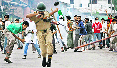 A policeman recoils in pain after being hit by an object thrown by a protester in Srinagar.