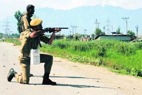 A policeman opens fire after people defied the curfew in Srinagar