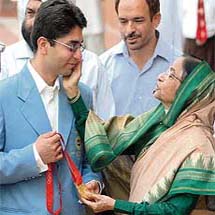 Abhinav Bindra gets a pat on the cheek from President Pratibha Patil as he shows her his Beijing Games gold medal in New Delhi