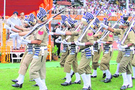 Punjab Chief Minister Parkash Singh Badal honours the parents of singer Ishmeet Singh; and (right) a contingent of the PAP takes part in a parade at a state-level function in Ludhiana on Friday.