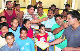 Wrestlers celebrate with coach Darshan Lal at Sports Complex, Sector 42