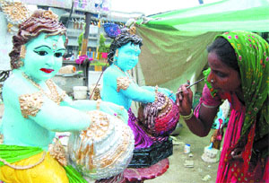 With Janmashtami a day away, a woman gives final touches to idols of Lord Krishna in Amritsar.