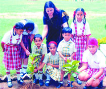 Students and principal of DIPS, Karol Bagh, plant saplings on the school premises.