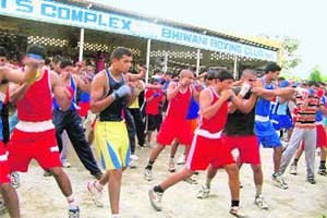 Unable to find room in the small practice ring, boxers at the Bhiwani Boxing Club practice their moves outside the ring