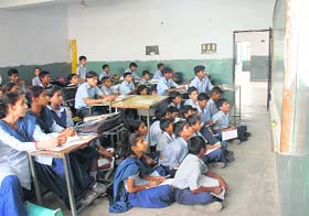Students sit on the floor to read the blackboard at a government school in Chandigarh