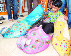 Punjabi juttis have become a tourist attraction in the holy city. A shopkeeper displays giant juttis to attract customers in Amritsar.