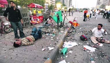 Injured people lie on a road after a bomb explosion near Gopaldas Building at Connaught Place in New Delhi