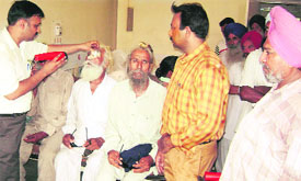 Dr Rajesh Garg examines eye patients at the Ahmedgarh civil hospital on Monday.