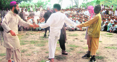 Masked members of the outlawed militant group Tehreek-e-Taliban Pakistan hold a criminal (centre) as their colleague beats him during an open trial by Islamic militants at Matta in the restive northwestern Swat district on Thursday. Swat has experienced numerous clashes and bombings since radical pro-Taliban cleric Maulana Fazlullah launched a violent campaign to enforce harsh Islamic Sharia law.