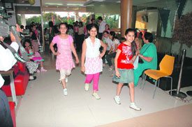 Girls parade on a makeshift ramp during a birthday party, and (right) the finalists get a tiara and a sash