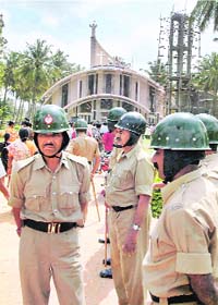 Policemen stand guard outside St James Church in the Mariyanpalya area in Bangalore