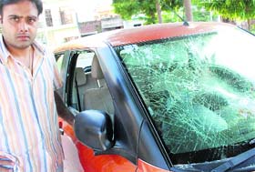 A resident of Sector 70 shows a badly damaged car