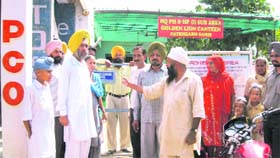 Ex-servicemen argue with officials of the canteen stores department in Fatehgarh Sahib