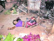 an injured woman waits for help after serial blasts in Agartala