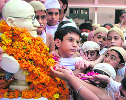 BAPU’S CHILDREN: Students garland the statue of Mahatma Gandhi on the eve of Gandhi Jayanti in Amritsar on Wednesday.