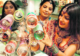 Women watch the new collection of bangles ahead of Karva Chauth at a shop in Ludhiana on Sunday.